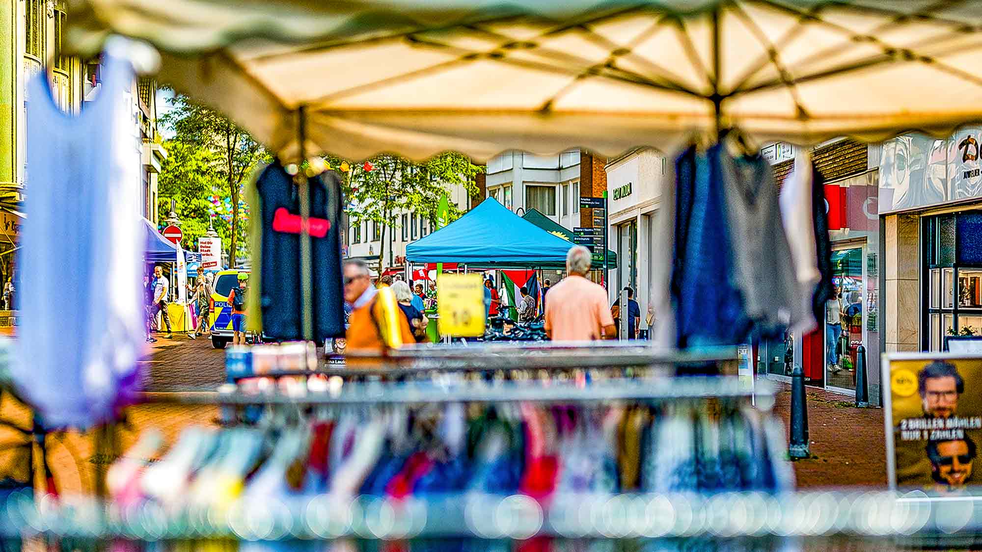 Klamotten auf dem Wochenmarkt Gütersloh, im Hintergrund Kommunalwahl 2025, »CDU«, »Grüne«, »Linke« Klamotten auf dem Wochenmarkt Gütersloh, im Hintergrund Kommunalwahl 2025, »CDU«, »Grüne«, »Linke«