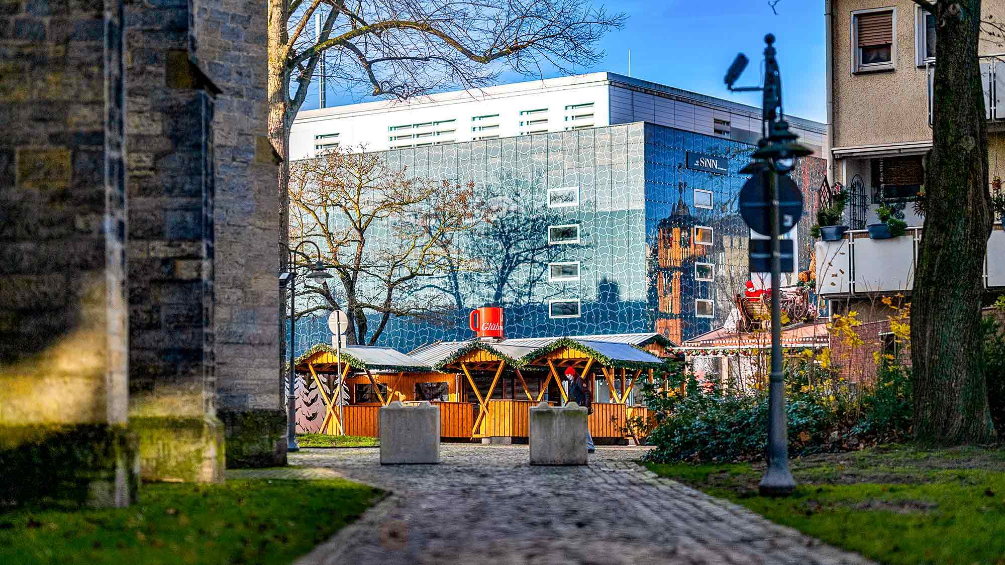 NOW Commons: Gütersloher Weihnachtsmarkt, Ensemble Roggi’s Glühweinstube, im Hintergrund das alte Karstadt Kaufhaus, Martin Luther Kirche NOW Commons: Gütersloher Weihnachtsmarkt, Ensemble Roggi’s Glühweinstube, im Hintergrund das alte Karstadt Kaufhaus, Martin Luther Kirche
